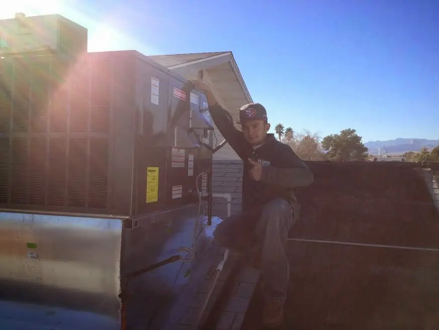 HVAC technician performing AC Tune-Up on a rooftop unit in Fridley